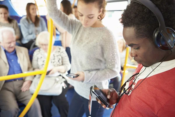 Pasażerów korzystających z urządzeń mobilnych na podróż autobusem — Zdjęcie stockowe