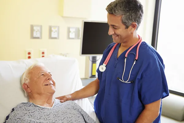 Мужской врач беседует со старшим пациентом — стоковое фото