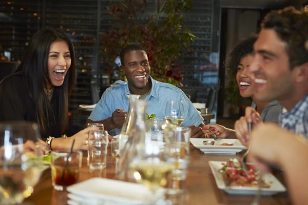 Grupo de amigos disfrutando de la comida en el restaurante —  Fotos de Stock