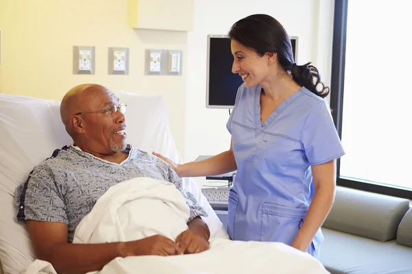 Infirmière parlant à un patient masculin âgé dans une chambre d'hôpital — Photo