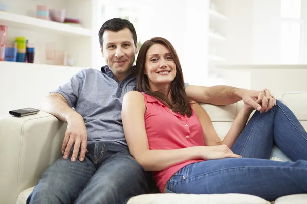 Spansktalande familj sitter på soffan tittar på tv tillsammans — Stockfoto