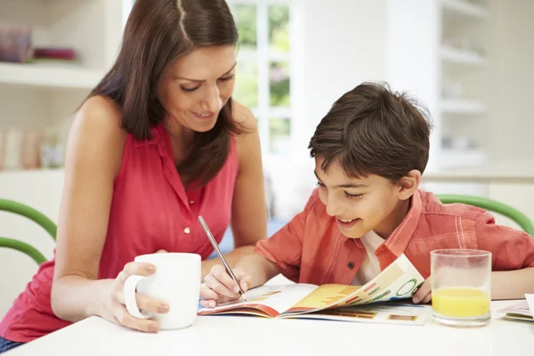 Matka pomáhá synovi s domácím úkolem — Stock fotografie