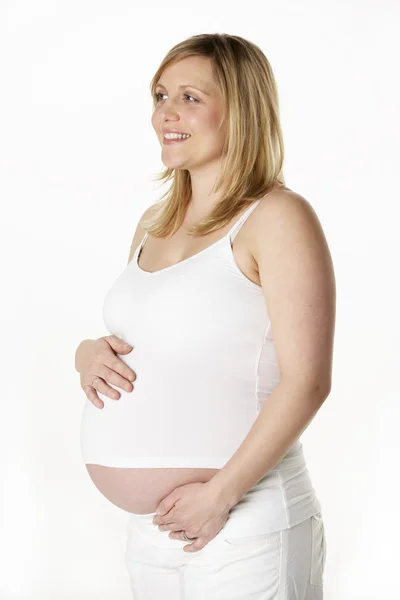 Estudio retrato de 7 meses embarazada mujer usando blanco —  Fotos de Stock