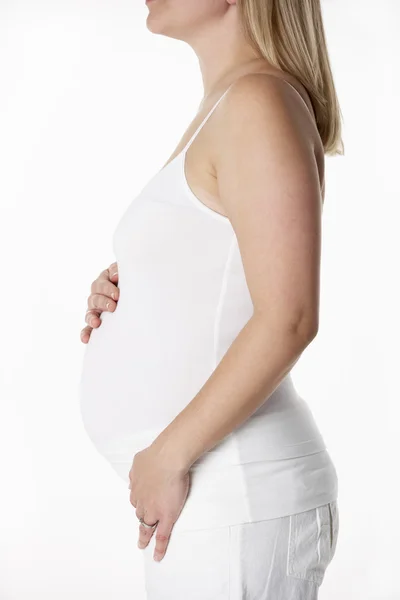 Close-up van studio portret van 5 maanden zwangere vrouw dragen whit — Stockfoto