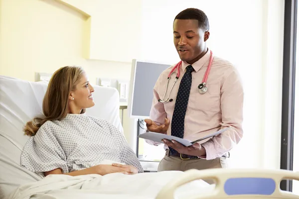 Médecin parlant à une patiente dans une chambre d'hôpital — Photo
