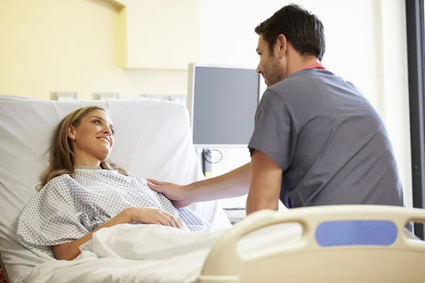 Infirmière masculine parlant avec une patiente dans une chambre d'hôpital — Photo