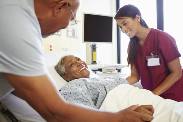 Infirmière parlant à un couple âgé dans une chambre d'hôpital — Photo