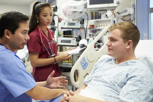 Paciente masculino conversando com a equipe médica na sala de emergência — Fotografia de Stock