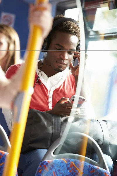 Człowiek sobie słuchawki słuchać muzyki na podróż autobusem — Zdjęcie stockowe