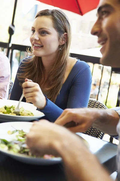 Mujer disfrutando de la comida en el restaurante al aire libre con amigos — Foto de Stock