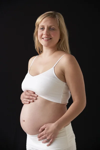 Retrato de mujer embarazada de 5 meses vestida de blanco con respaldo negro —  Fotos de Stock