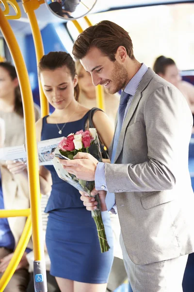 Hombre va a la fecha en autobús celebración de racimo de flores — Foto de Stock