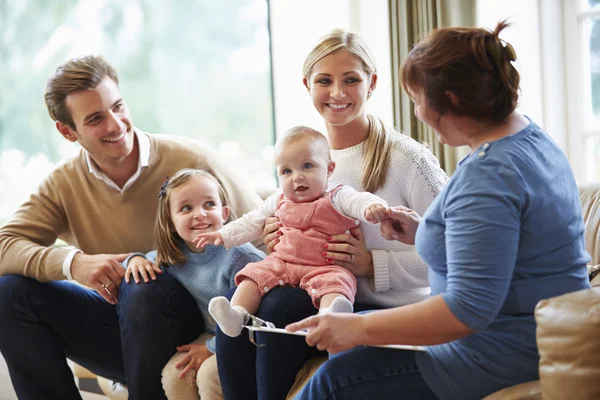 Gezondheid bezoeker praten met familie met jonge baby — Stockfoto