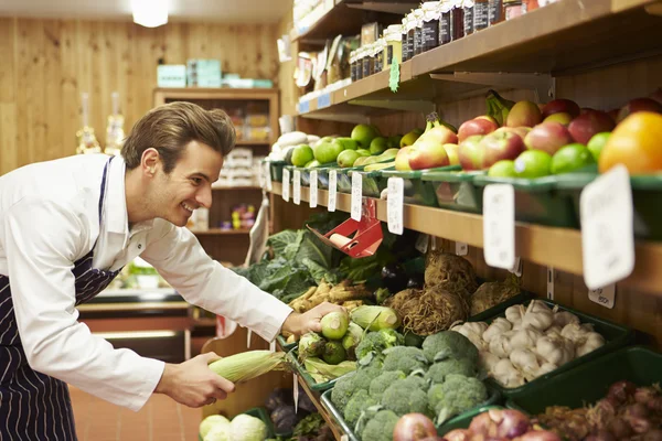 Mężczyzna sprzedawczyni warzyw licznik sklep — Zdjęcie stockowe