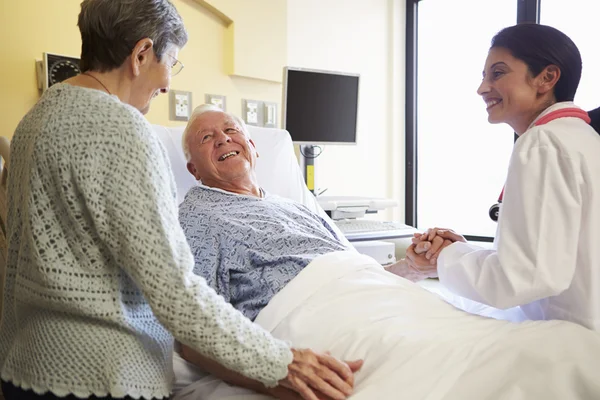 Kvinnliga läkare pratar med äldre par i sjukhussal — Stockfoto