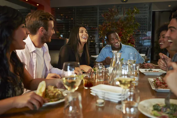 Grupo de amigos disfrutando de la comida en el restaurante —  Fotos de Stock