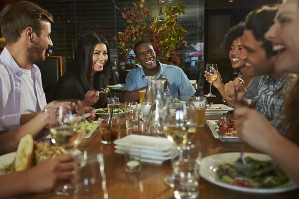 Група друзів насолоджуючись їжею в ресторані — стокове фото