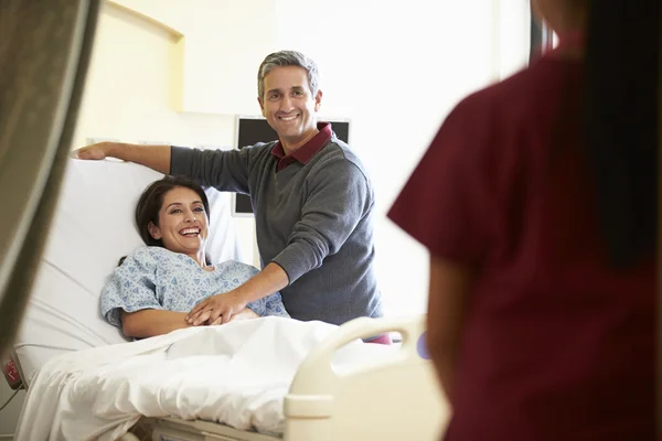 Echtgenoot bezoekende vrouw in het ziekenhuis en praten te verplegen — Stockfoto