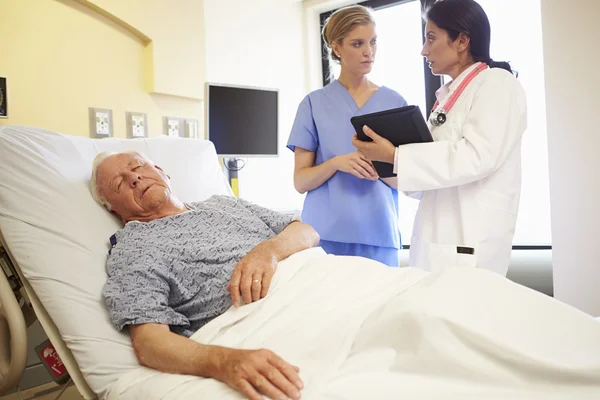 Réunion de l'équipe médicale alors que l'homme âgé dort dans la chambre d'hôpital — Photo