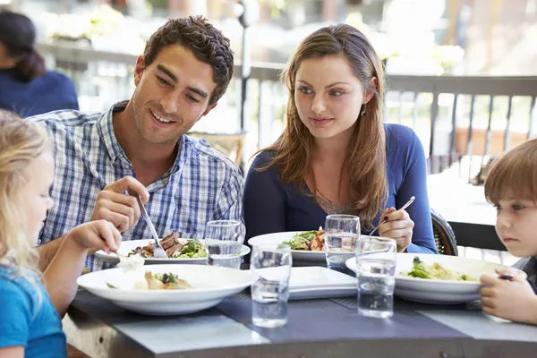 Familia disfrutando de la comida en el restaurante al aire libre — Foto de Stock