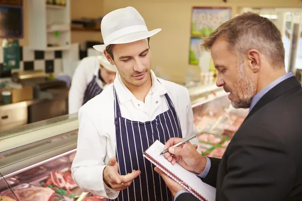 De manager van de Bank ontmoeting met eigenaar van slagers winkel — Stockfoto