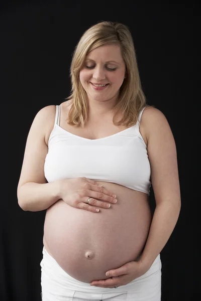 Portret van 9 maanden zwangere vrouw dragen wit op zwart backg — Stockfoto