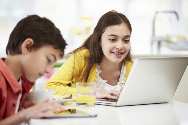 Niños con tableta digital y computadora portátil en el desayuno —  Fotos de Stock