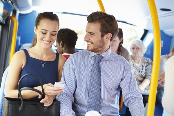 Бизнесмен и женщина рассматривают мобильный телефон в автобусе — стоковое фото