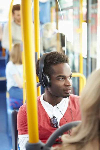 Człowiek sobie słuchawki słuchać muzyki na podróż autobusem — Zdjęcie stockowe