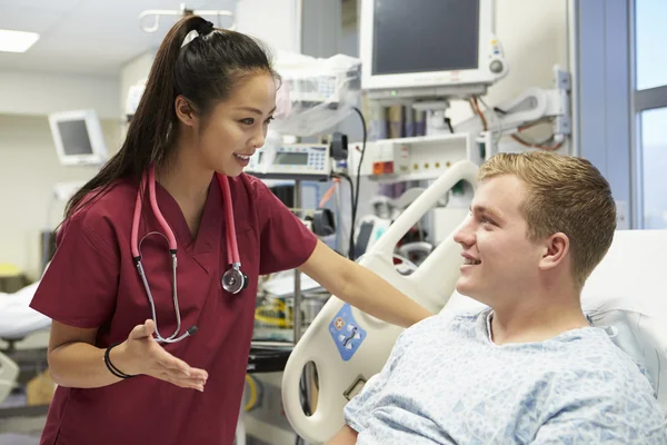 Jeune patient masculin parlant à une infirmière dans une salle d'urgence — Photo