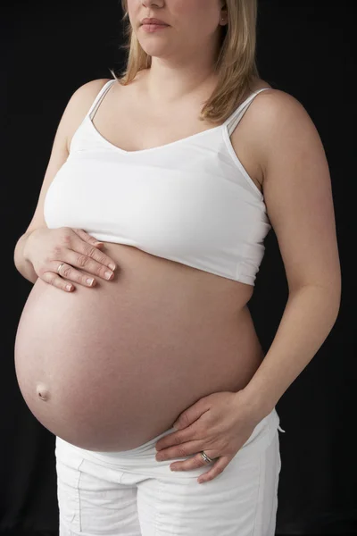 Portret kobiety w ciąży 9 miesięcy na czarnym tle z bliska — Zdjęcie stockowe