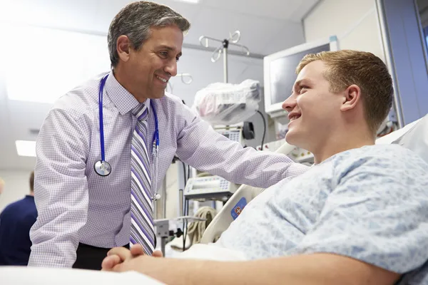 Paciente masculino joven que habla con el consultor en la sala de emergencias — Foto de Stock