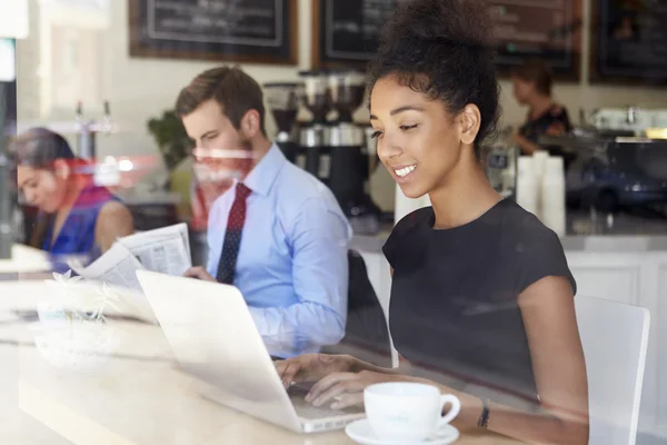 Mujer de negocios usando el ordenador portátil en la cafetería — Foto de Stock