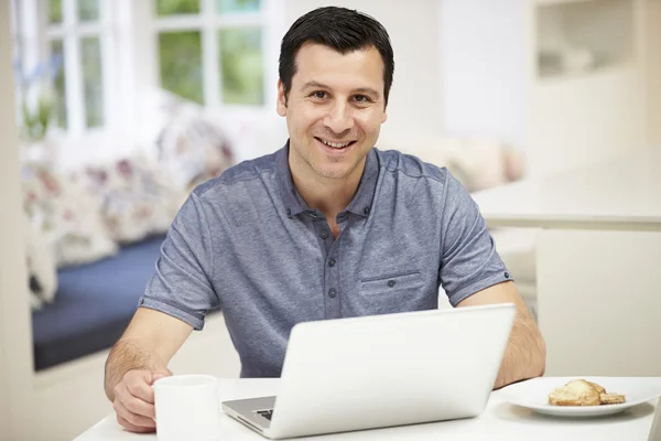 Spansktalande man använder laptop i köket hemma — Stockfoto