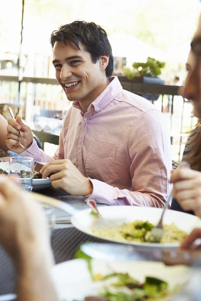Мужчина, наслаждающийся едой в ресторане на открытом воздухе — стоковое фото