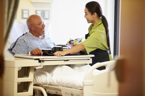 Paciente masculino mayor que recibe servicio de comida en cama de hospital —  Fotos de Stock