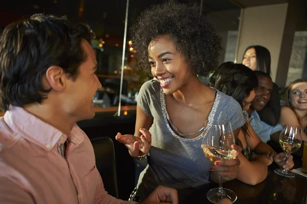 Casal desfrutando de bebida no bar com amigos — Fotografia de Stock