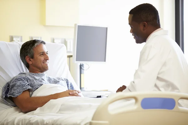 Doctor hablando con el paciente masculino en la habitación del hospital — Foto de Stock