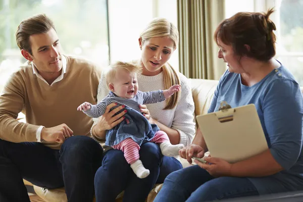 Assistente social visita família com bebê jovem — Fotografia de Stock