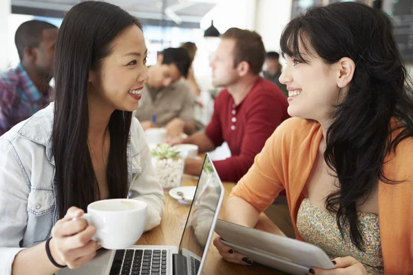 Due amiche che si incontrano in una caffetteria affollata — Foto Stock