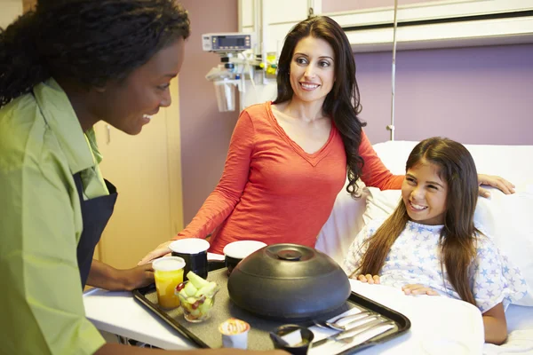 Jong meisje wordt geserveerd lunch in ziekenhuis bed — Stockfoto