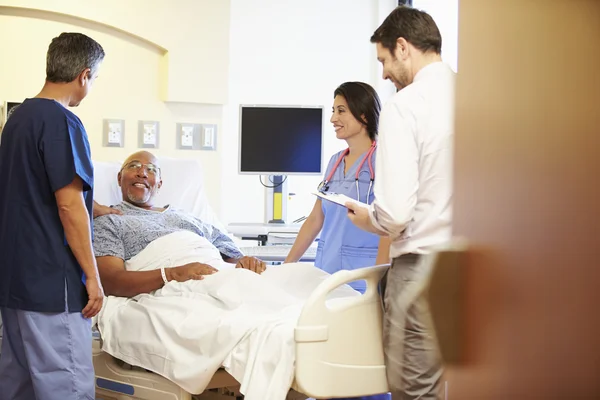 Lékařský tým setkání s starší muž v nemocničním pokoji — Stock fotografie