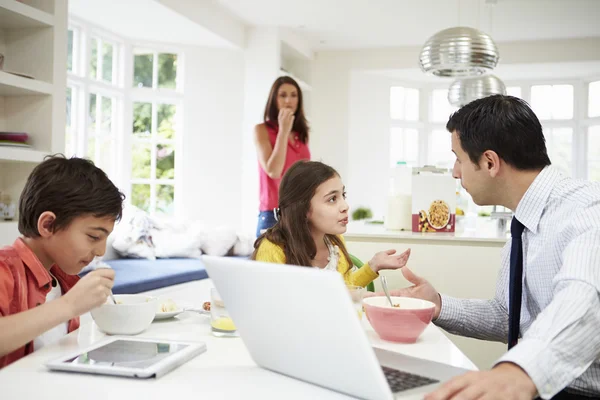 Familia usando dispositivos digitales discutiendo durante el desayuno — Foto de Stock