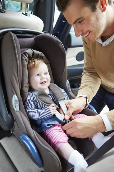 Vater setzt Baby in Autositz — Stockfoto