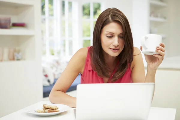 Mujer hispana usando computadora portátil en la cocina en casa — Foto de Stock