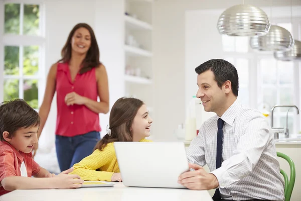 Familie nutzt digitale Geräte am Frühstückstisch — Stockfoto