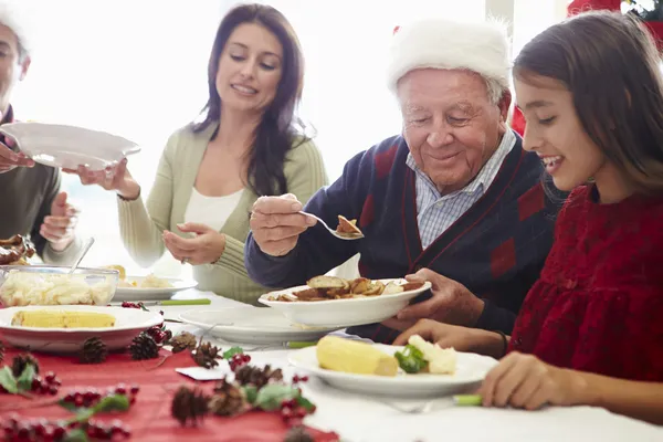 Famiglia multi generazione che si gode il pasto di Natale a casa Foto Stock Royalty Free