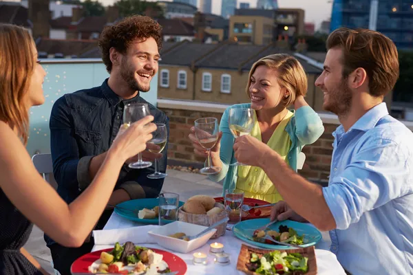 Groupe d'amis manger des repas sur la terrasse sur le toit — Photo