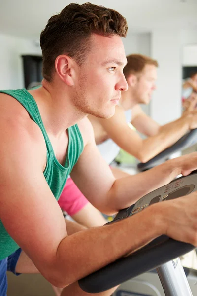 Männer trainieren im Fitnessstudio an Radsportgeräten — Stockfoto