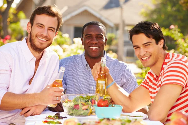 Drie mannelijke vrienden genieten van de maaltijd — Stockfoto